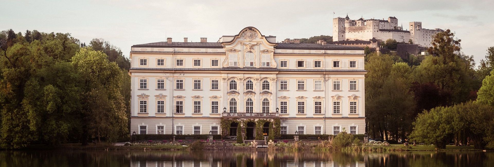 Schloss Leopoldskron with the lake in the foreground and Salzburg's fortress in the background (c) Richard Schabetsberger