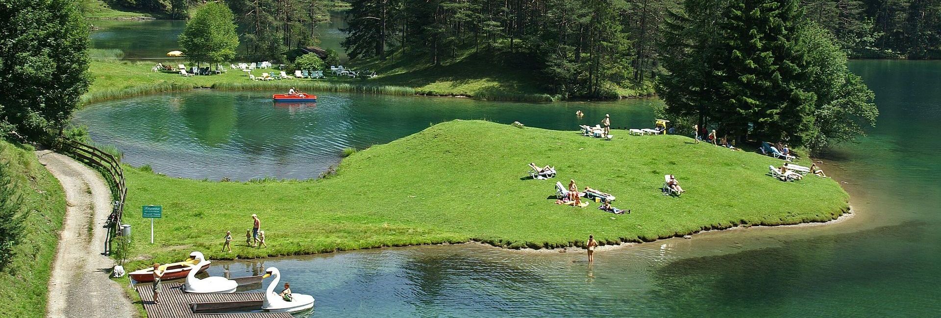 Sunbathing lawn with boats at lake Fernsteinsee in Tyrol