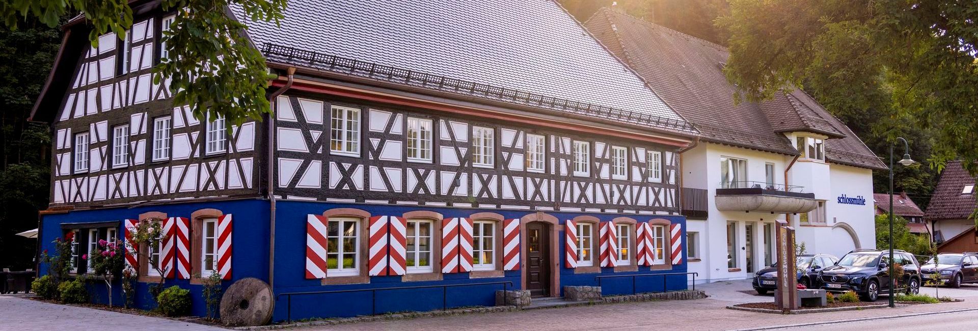 Timberframed hotel Schlossmühle Glottertal in white and blue with red and white striped window bars (c) Photo Joss Andres