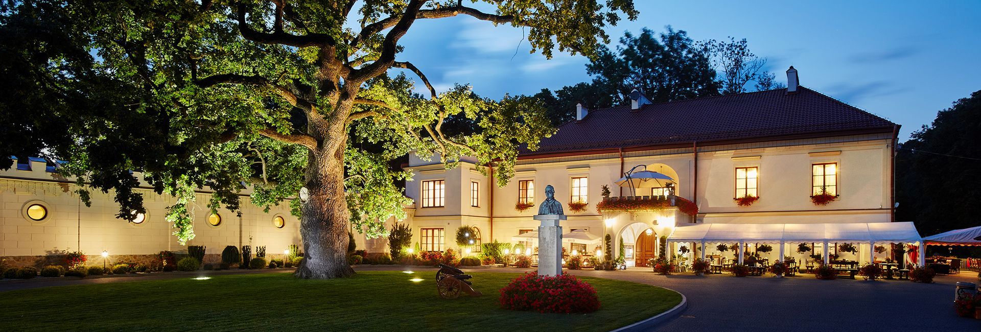 Dubiecko Castle by night in a romantic light with a beautiful old tree in the foreground (c) Dobiecko Castle